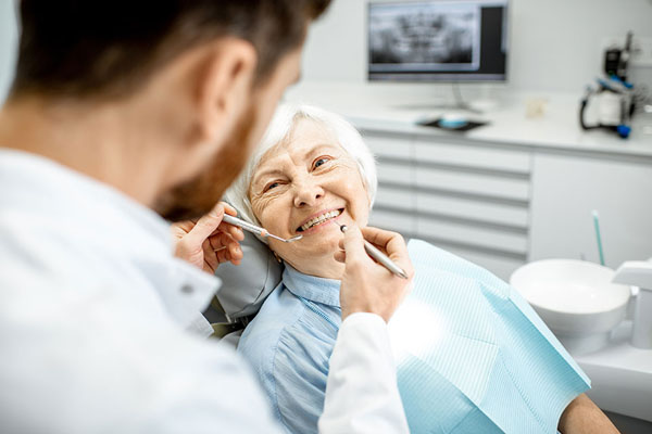 elderly woman receiving a routine dental cleaning