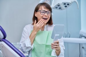 woman admiring her smile in dentist chair