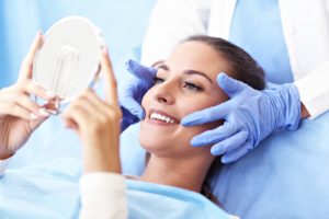 woman admiring smile in dentist chair