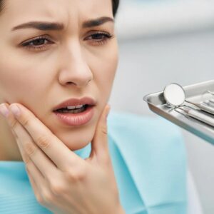 person-holding-jaw-in-discomfort-illustrating-common-symptoms-of-bruxism